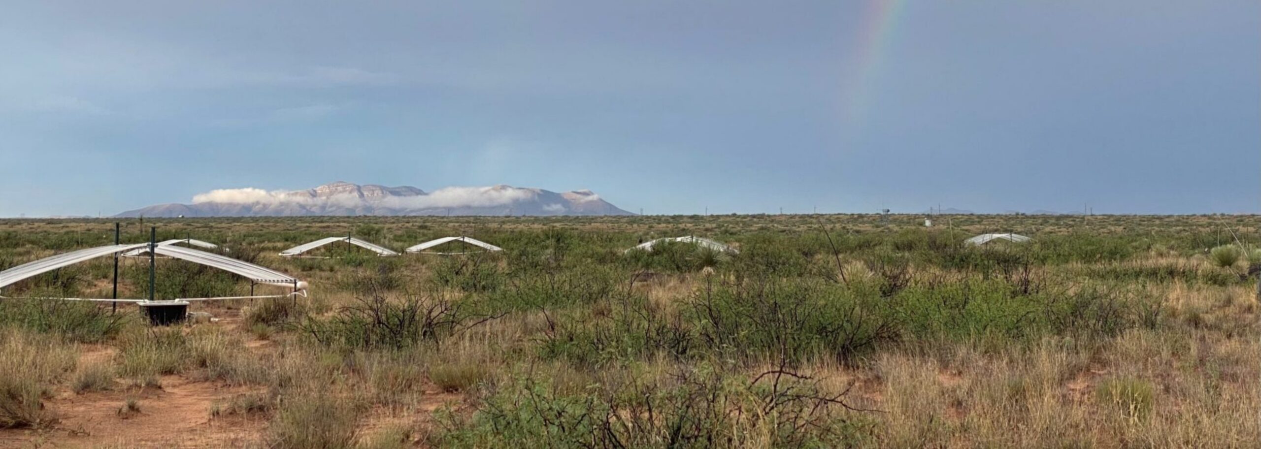 Experimental stations set up in an arid land with mountains in background,