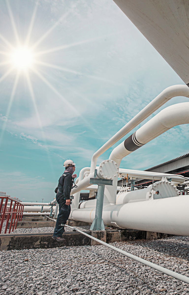 Man standing beside some pipelines.