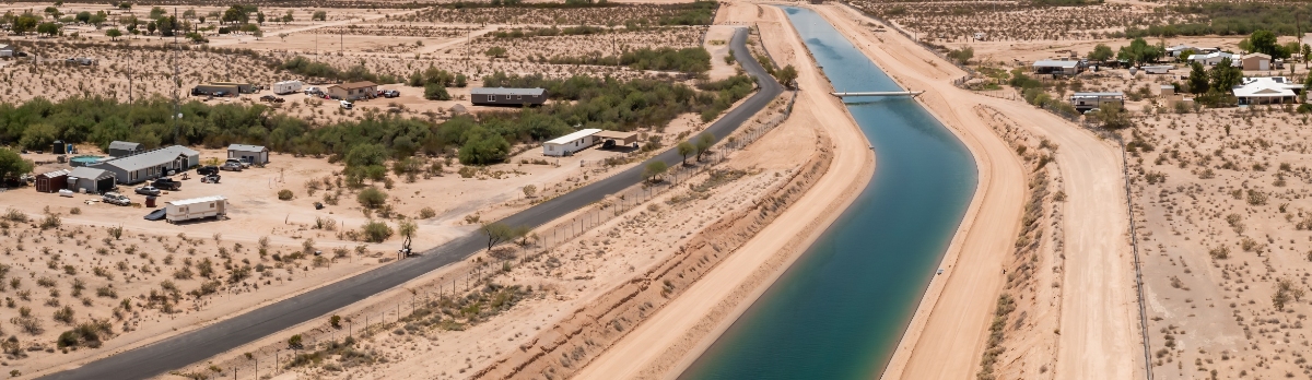 A canal in Arizona with desert landscape along both sides.