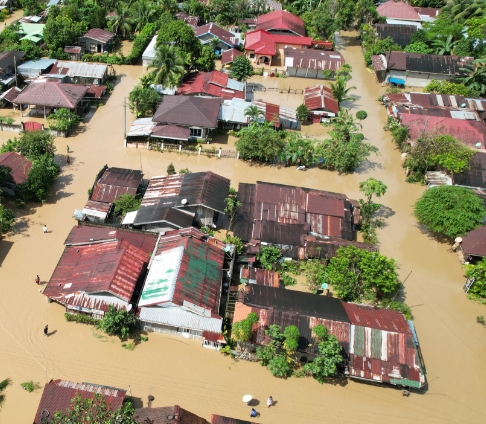 Aerial view of a neighborhood submerged in brown floodwater.