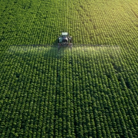 A tractor spraying a large crop.