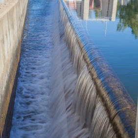 A manmade waterfall flowing into a canal.