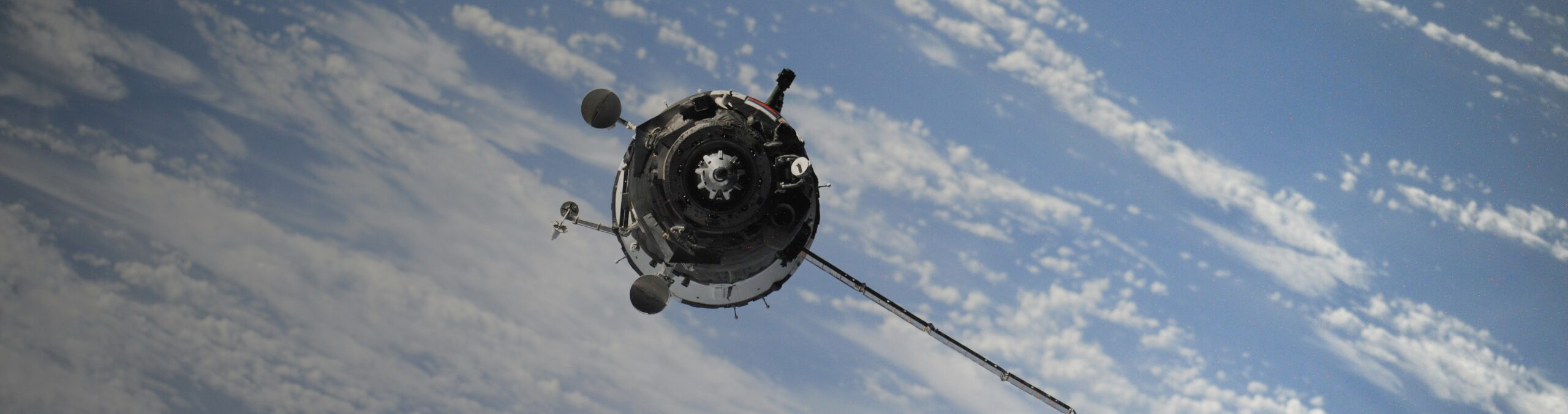 Satellite with clouds below it.
