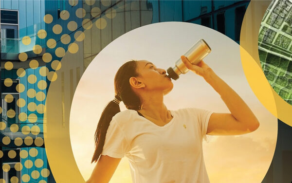 Woman drinking from a water bottle on a background of colorful circles